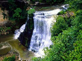 Tennessee, Burgess Falls. Image a distance shot of a waterfall with trees on the right side. Image is in full colour.
