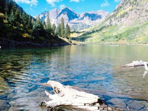Colorado, Maroon Lake. Image is of the lake viewed from the ground with tree and mountains in the background. Image is in full colour. 